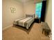 Cozy bedroom featuring neutral tones, a queen bed, and a window for natural light at 5005 Blue Serenity Ct, Denver, NC 28037