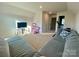 Cozy bonus room featuring a gray sectional sofa, media console, dollhouse, and neutral carpeting at 5005 Blue Serenity Ct, Denver, NC 28037