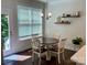 Bright dining area with a round table, decorative shelves, and a view to the backyard through a glass door at 5005 Blue Serenity Ct, Denver, NC 28037