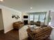 Open living room with a fireplace, large windows, and hardwood floors at 5005 Blue Serenity Ct, Denver, NC 28037