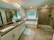 Bright bathroom features a double vanity, a separate shower, and a soaking tub at 5005 Blue Serenity Ct, Denver, NC 28037