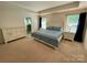Spacious main bedroom with neutral carpet, white furniture, and two windows for ample lighting at 5005 Blue Serenity Ct, Denver, NC 28037