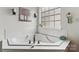 Bathroom featuring a tiled corner tub with chrome hardware, garden window and decor at 5021 Meadow Woods Dr, Lowell, NC 28098