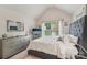 Light-filled bedroom featuring a modern headboard, large window, and mirrored dresser at 5021 Meadow Woods Dr, Lowell, NC 28098