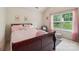 Bright bedroom featuring a cozy bed with pink linens and natural light from the window at 5021 Meadow Woods Dr, Lowell, NC 28098