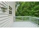 A view of the deck of a beautiful home, showcasing a railing and view into the forest at 5021 Meadow Woods Dr, Lowell, NC 28098
