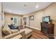 Bright living room with wood floors, a fireplace, and a comfortable sectional couch with blue pillows at 5021 Meadow Woods Dr, Lowell, NC 28098