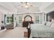 Spacious main bedroom with tray ceiling, a large bed, dresser, and sitting area at 5021 Meadow Woods Dr, Lowell, NC 28098