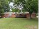 Brick home featuring a wooden patio and views of the spacious backyard at 5628 White Store Rd, Wingate, NC 28174