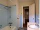 Retro bathroom with light blue tiles, a shower-tub combo, and an adjacent doorway at 5628 White Store Rd, Wingate, NC 28174