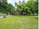 Well-manicured lawn surrounds this brick home with mature trees and a long driveway at 5628 White Store Rd, Wingate, NC 28174