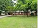 Charming brick home features a lush lawn, mature trees, and inviting curb appeal at 5628 White Store Rd, Wingate, NC 28174