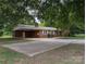 Brick home with a porte-cochere and a spacious front yard with mature trees at 5628 White Store Rd, Wingate, NC 28174
