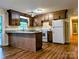 Well-lit kitchen with dark wood cabinets, granite countertops, and stainless steel appliances at 5628 White Store Rd, Wingate, NC 28174