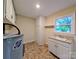 Functional laundry room with a utility sink, cabinetry, and natural light from the window at 5628 White Store Rd, Wingate, NC 28174