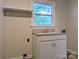 Laundry room with a utility sink, lower cabinet, a shelf, and natural light from a window at 5628 White Store Rd, Wingate, NC 28174