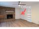 Cozy living room features a brick fireplace, vinyl floors, a ceiling fan, and built-in shelving at 5628 White Store Rd, Wingate, NC 28174