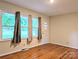 Well-lit living room featuring hardwood floors, large windows offering natural light, and a neutral color scheme at 5628 White Store Rd, Wingate, NC 28174