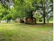 Brick home with mature trees, green grass, and landscape design at 5628 White Store Rd, Wingate, NC 28174