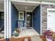 Inviting front entrance of townhome features a rocking chair, wood accents, and stylish decor at 54 Woodsdale Se Pl, Concord, NC 28025