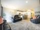Spacious open-concept living area with modern furnishings, including a leather sofa and access to a kitchen area at 54 Woodsdale Se Pl, Concord, NC 28025