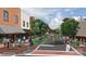 Street view, featuring lush greenery, pedestrian-friendly pathways, and unique local businesses at 54 Woodsdale Se Pl, Concord, NC 28025