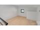 Attic space with hardwood floors, bright lighting and a small window at 5930 Midsomer Rd, Charlotte, NC 28214