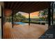 Exterior view of a spacious wooden deck overlooking the pool and lake at 5930 Midsomer Rd, Charlotte, NC 28214