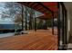 Modern backyard deck with an outdoor kitchen, pool, and serene lake views at 5930 Midsomer Rd, Charlotte, NC 28214