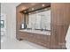 Bathroom with double sink vanity and dark wood cabinets with recessed lighting above the mirror at 5930 Midsomer Rd, Charlotte, NC 28214