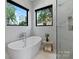 Stylish bathroom featuring soaking tub and marble tiled walls at 5930 Midsomer Rd, Charlotte, NC 28214