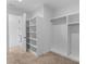 Clean, minimalist walk-in closet with white shelving and hanging racks for optimal organization and storage at 5930 Midsomer Rd, Charlotte, NC 28214