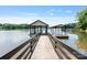 Exterior shot of a private boat dock on a serene lake surrounded by trees at 5930 Midsomer Rd, Charlotte, NC 28214