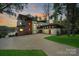 Stunning modern home featuring a spacious driveway, three-car garage, and picturesque lake views at 5930 Midsomer Rd, Charlotte, NC 28214
