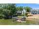 Modern waterfront home featuring a private dock and lush landscaping at 5930 Midsomer Rd, Charlotte, NC 28214