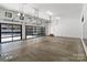 Spacious garage with multiple large garage doors and bright overhead lighting at 5930 Midsomer Rd, Charlotte, NC 28214