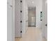 Bright hallway with tile flooring leads to a modern glass-enclosed shower and features minimalist white doors and trim at 5930 Midsomer Rd, Charlotte, NC 28214
