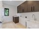 Bright laundry room featuring plenty of cabinet space, a sink and hardwood floors at 5930 Midsomer Rd, Charlotte, NC 28214