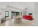 Open-concept living area with lake views, light wood floors, dining table, and a red reclining sectional sofa at 5930 Midsomer Rd, Charlotte, NC 28214
