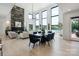 Open-concept living and dining area with lake views, featuring a stone fireplace, high ceilings, and modern decor at 5930 Midsomer Rd, Charlotte, NC 28214