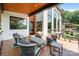 Outdoor deck seating area with a view of the main house and surrounding trees at 5930 Midsomer Rd, Charlotte, NC 28214