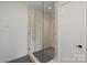 Sleek glass shower with modern fixtures and gray tiled floor at 5930 Midsomer Rd, Charlotte, NC 28214