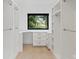 Walk-in closet with custom shelving and drawers featuring a window for natural light at 5930 Midsomer Rd, Charlotte, NC 28214