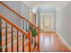 Welcoming foyer showcasing gleaming hardwood floors, a staircase with wooden railings, and a bright entryway leading into the home at 6057 Erie View Ct, Denver, NC 28037