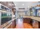 Open kitchen featuring stainless steel appliances, wooden floors, and granite countertops at 6057 Erie View Ct, Denver, NC 28037