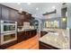 Kitchen featuring granite countertops, dark wood cabinets, and stainless steel appliances at 6057 Erie View Ct, Denver, NC 28037