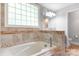 Bathroom with tiled walls, tub, and glass block window at 6294 Southlake Dr, Hickory, NC 28601