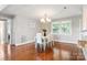 Cozy dining room with hardwood floors, chandelier lighting, and large windows providing natural light at 6294 Southlake Dr, Hickory, NC 28601
