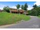 Charming brick home with a spacious wooden deck, lush lawn, and a paved driveway at 6294 Southlake Dr, Hickory, NC 28601