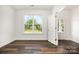 Bright, empty room with hardwood floors and large window providing abundant natural light and backyard view at 718 Lithia Inn Rd, Lincolnton, NC 28092